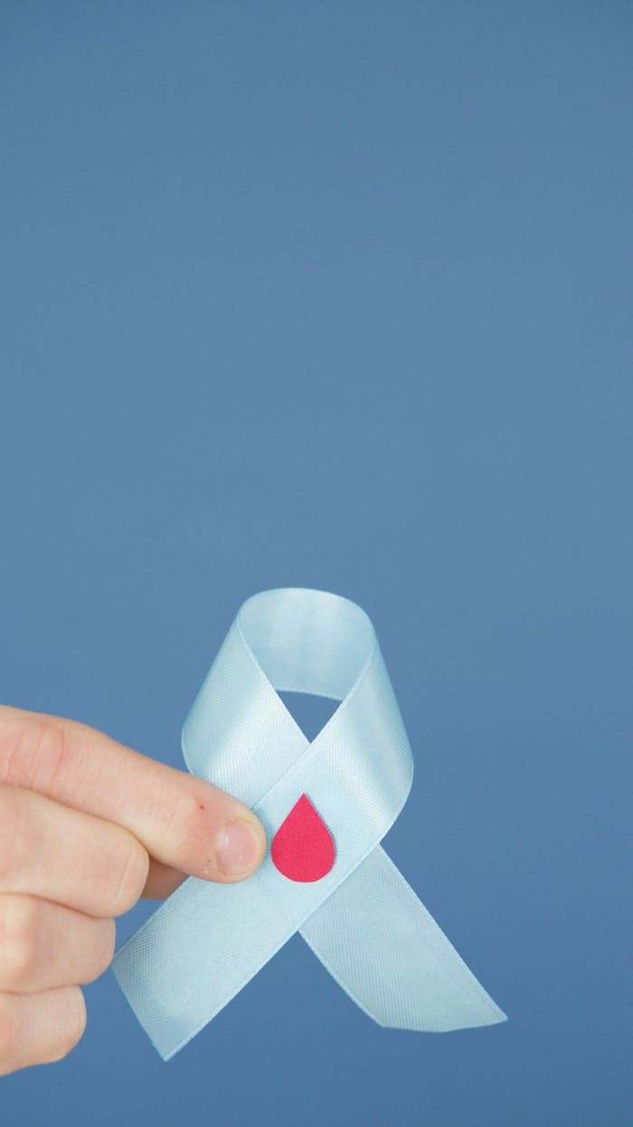 Services Blue awareness ribbon with a red blood drop symbolizing diabetes support and health.